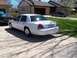 2003 Ford Crown Victoria - A white Ford Crown Victoria is parked in a driveway with a basketball hoop visible overhead.