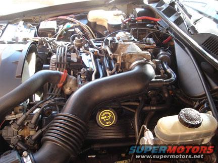Engine bay with air intake hoses, engine oil cap, and brake fluid reservoir