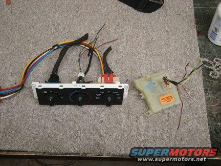 HVAC control panel with three knobs and wiring, next to a beige actuator with an orange sticker and wiring