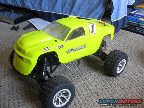 Yellow remote control truck with "F150" and "Traxxas" decals