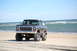 1979 Ford Bronco - This lifted 1979 Ford Bronco is parked on a sandy beach with the ocean in the background.