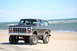 1979 Ford Bronco - A lifted 1979 Ford Bronco is parked on a beach with the ocean in the background.