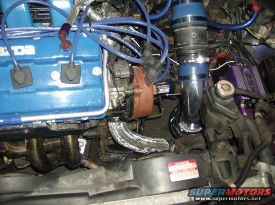 Mazda engine bay with blue cover, chrome intake, and ZEX nitrous kit