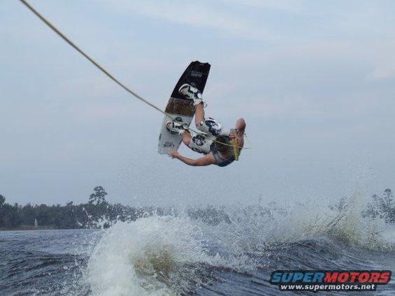 Wakeboarder mid-air over choppy water, pulled by unseen boat
