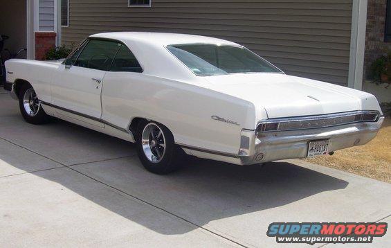 White 1965 Pontiac Catalina coupe parked on a concrete driveway, rear quarter view