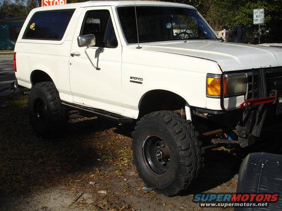 1989 Ford Bronco, lifted with large off-road tires, parked outdoors