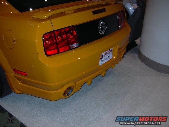 Yellow car rear bumper with dual exhaust pipes and a license plate frame from Erickson Auto Trim