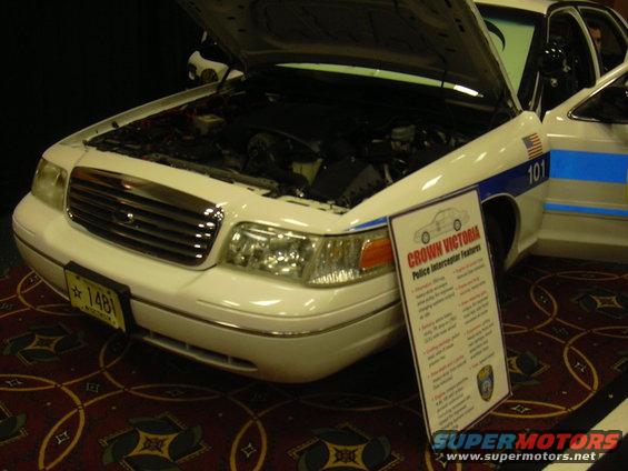 1996 Ford Crown Victoria police car, front view with hood open, white with blue stripe