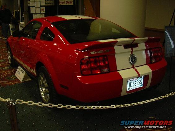 Red 2007 Shelby GT500 rear view with white stripes and custom plate