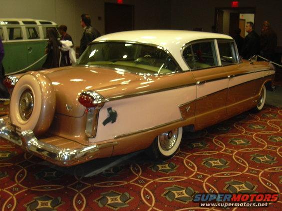 Two-tone rose gold and pink sedan with a continental kit and whitewall tires