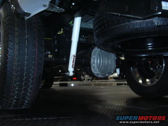 Underbody view of a vehicle's spare tire, differential, and Rancho shock absorber