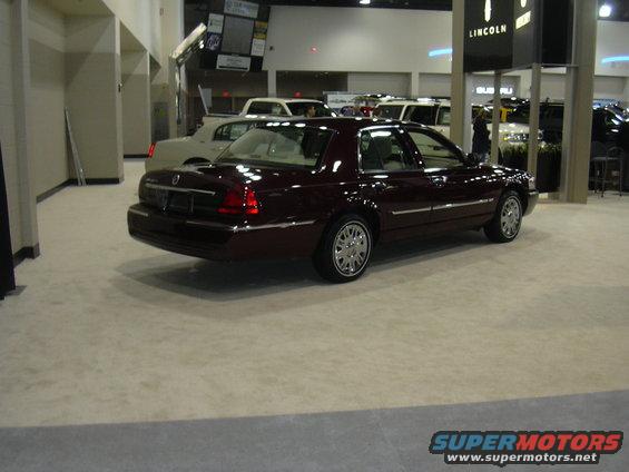 Maroon Mercury Grand Marquis parked indoors with other vehicles in background