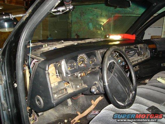 Interior dashboard with exposed wiring and a steering wheel