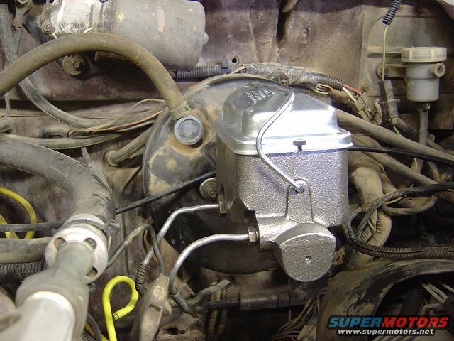 Close-up of a vehicle's engine bay showing the master cylinder and brake booster assembly