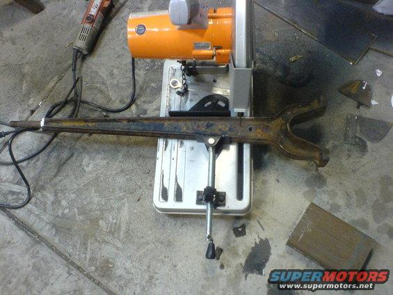 Rusty suspension arm clamped to a metal cutting saw