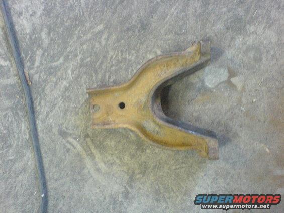 yellowish metal automotive part with a U-shaped opening and a hole