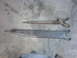 1967 Ford Bronco - Comparison of a rusty and a cleaned suspension control arm on a concrete surface.