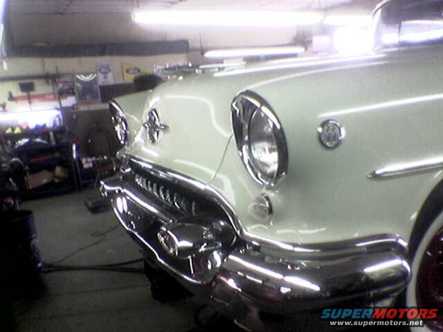 White classic car front end with chrome grille and round headlights