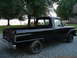 1966 Ford F-100 - This black 1966 Ford F-100 pickup truck is parked on a gravel driveway near a body of water.