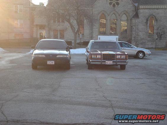 1992 Ford Crown Victoria parked in front of a building with two other cars