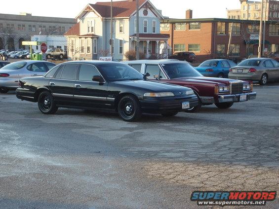 Black 1992 Ford Crown Victoria parked next to a maroon Lincoln Town Car