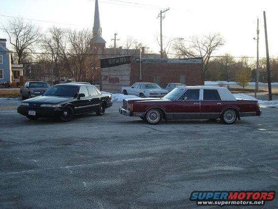 Black sedan and maroon sedan parked side-by-side
