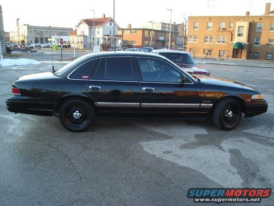 1992 Ford Crown Victoria parked on street, side view. Another car is parked behind it