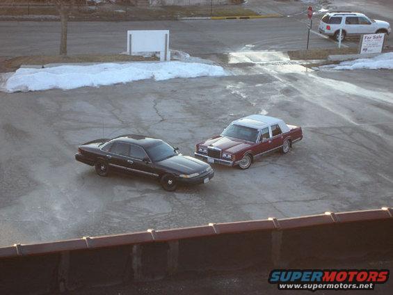 Black 1992 Ford Crown Victoria parked next to a maroon sedan