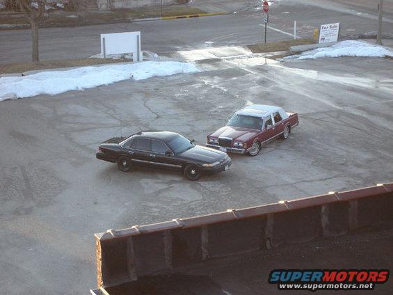 1992 Ford Crown Victoria and a red Lincoln Town Car parked in a lot