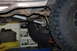 1996 Ford Bronco - Close-up of a vehicle's driveshaft and suspension components, including a tire and leaf spring.