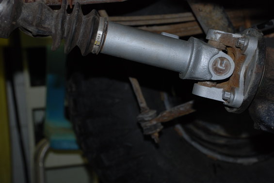 Close-up of a driveshaft U-joint and boot. Some markings are visible on the boot clamp