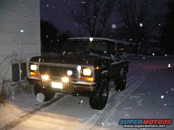 1979 Ford Bronco front view in snow with headlights on