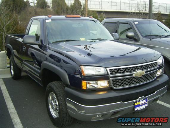 Dark blue Chevrolet Silverado pickup truck parked next to another vehicle