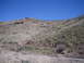1996 Ford Bronco - A wide view of a dry, rocky hillside with minimal vegetation under a bright blue sky.