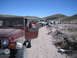 1996 Ford Bronco - Multiple Jeeps are lined up on a dusty trail with mountains in the background.