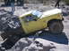 1996 Ford Bronco - A yellow Toyota pickup truck navigates a rocky off-road course, with another vehicle visible in the background.