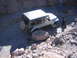 1996 Ford Bronco - A Jeep Wrangler TJ maneuvers through a challenging, rocky off-road path with a driver at the wheel.