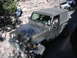 1996 Ford Bronco - A Jeep Wrangler navigates a challenging rocky terrain with other vehicles visible in the background.
