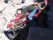 1996 Ford Bronco - Two people attempt to free a red Jeep Wrangler that is stuck on a rocky trail.