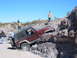 1996 Ford Bronco - A red Jeep Wrangler maneuvers through a challenging rocky obstacle on a sunny day.