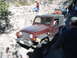 1996 Ford Bronco - A red Jeep Wrangler TJ navigates a rocky trail with other vehicles and people present.