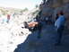 1996 Ford Bronco - A group of people observe a Jeep Wrangler navigating a difficult, rocky off-road path.