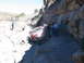 1996 Ford Bronco - A red Jeep Wrangler navigates a narrow, rocky off-road path with several onlookers.