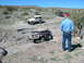 1996 Ford Bronco - Multiple Jeep Wranglers traverse a challenging off-road trail under a clear blue sky.