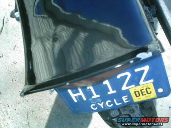 Blue license plate H112Z with yellow DEC sticker on a motorcycle fender