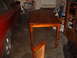 1988 Ford Bronco - A red car is parked in a garage next to a wooden dining table.