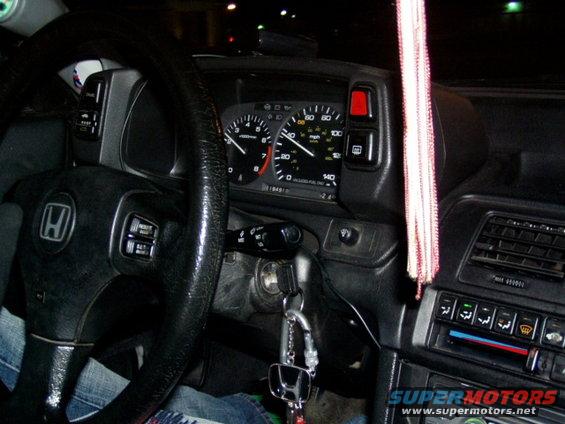 Interior view of a Honda with a steering wheel and dashboard gauges