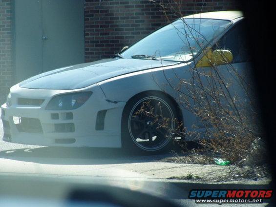 Modified front end of a car with yellow side mirror