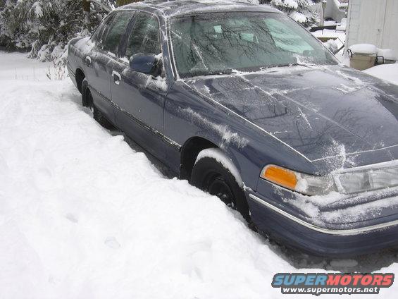 1996 Ford Crown Victoria partially buried in snow, front passenger side visible