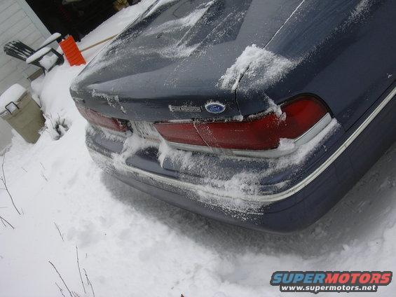 Dark blue Ford Crown Victoria rear in snow, showing taillights and trunk lid